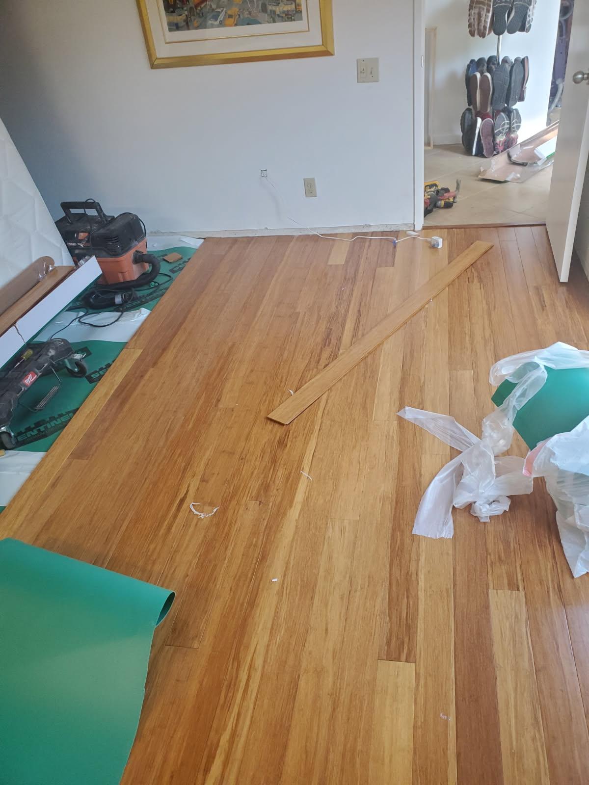 Wood plank flooring being installed in a bedroom