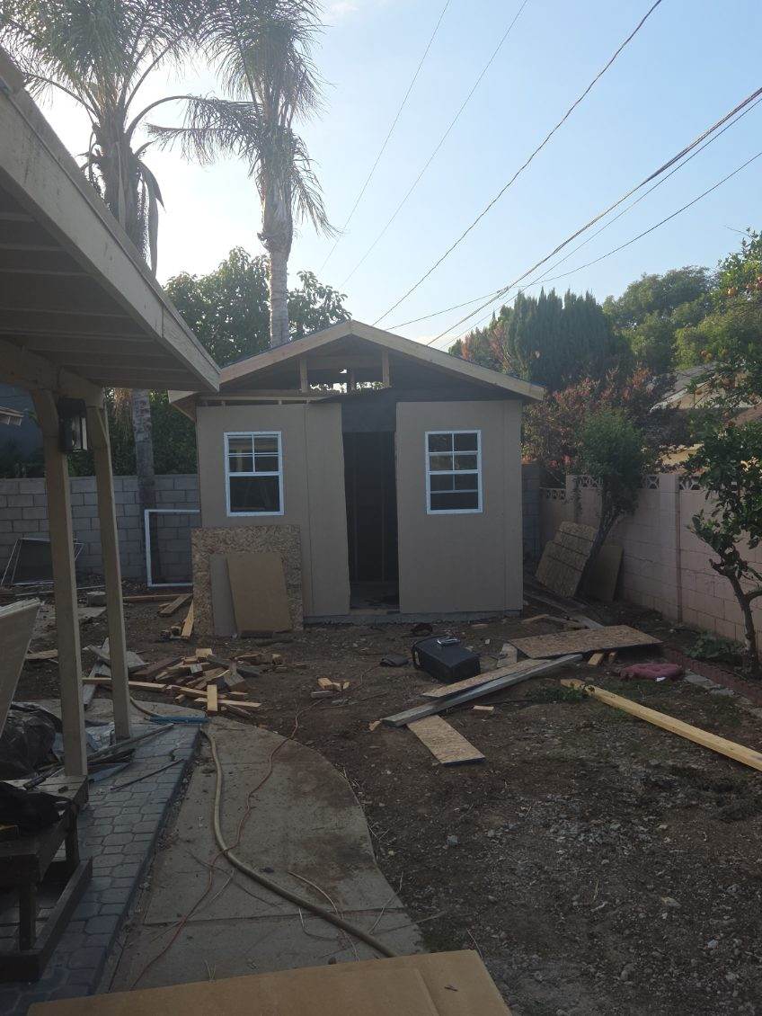 Backyard shed structure under construction with two windows