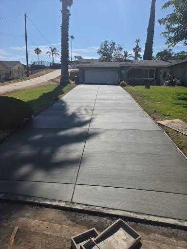 Freshly poured concrete driveway leading to a garage
