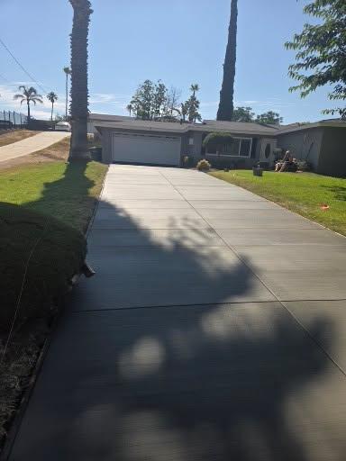 Long concrete driveway leading to a home